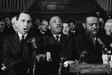 King leads the singing of “We Shall Overcome” after eulogizing a slain civil rights crusader, the Reverend James Reeb, Brown Chapel, Selma, Alabama. 1965.