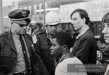 Police blocking demonstrators from approaching the courthouse in downtown, Selma, 1965.