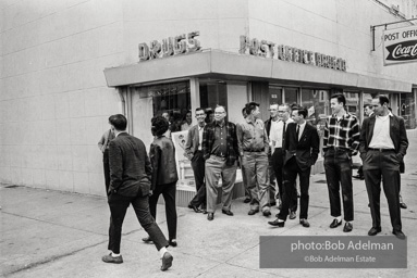 Hecklers stand together shouting insults as demostrators and participants of a voting rights drive pass by. Selma, AL, 1965.