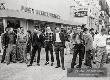 Hecklers stand together shouting insults as demostrators and participants of a voting rights drive pass by. Selma, AL, 1965.