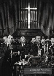 King leads the singing of “We Shall Overcome” after eulogizing a slain civil rights crusader, the Reverend James Reeb, Brown Chapel, Selma, Alabama. 1965.