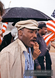 Braving the rain and singing, Martin Luther King leads the Selma to Montgomery march as it approaches it's finale in Montgomery, Alabama. 1965