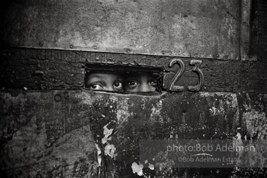 Peering through a mail slot,  Brooklyn,  New York City  1963