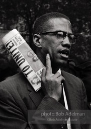 Malcolm X at a civil rights demonstration, Brooklyn, New York City.  1963-


“He was a fiery orator. No one could give tongue to the grievous wrongs suffered by African Americans in white America more trenchantly
than Malcolm. To get his message out to the assembled press, he
showed up at civil rights demonstrations as the photographer for The Messenger. We sometimes
discussed cameras and f- stops. I was surprised when he asked me how I thought the Black Muslim faith compared to Islam.
Emphasizing my limited knowledge, I very hesitantly favored Islam — it welcomed all races and was older and wiser. Some
time later he converted to Islam, which was a great revelation for him but, tragically, led to his assassination.”