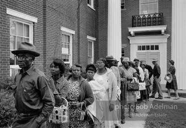 A new day dawns: Voters, most of them about to fill out their first-ever ballots, line up at the courthouse,  Camden, Alabama. 1966-

“The Voting Rights Act of 1965 changed everything, outlawing literacy tests and other barriers. It made it possible for thousands of black officials to eventually be elected in the South, and it certainly helped in
the election of two white southerners to the presidency. It was a large
factor in the gradual decrease of racial tension throughout the South. In a rare show of unity, more than forty years after the Voting Rights Act was passed, Congress renewed the measure unanimously.”