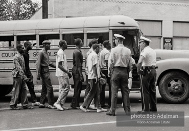 Arrested protestors are loaded onto a bus and taken to a detention center. Birmingham, AL, 1963.