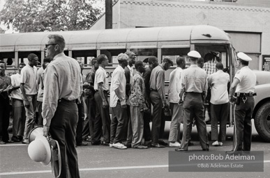 Arrested protestors are loaded onto a bus and taken to a detention center. Birmingham, AL, 1963.