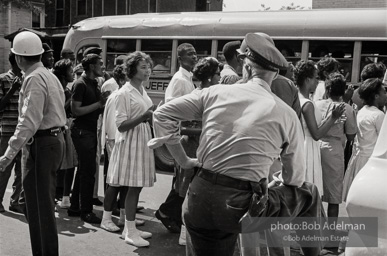 Arrested protestors are loaded onto a bus and taken to a detention center. Birmingham, AL, 1963.