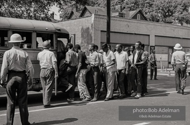 Arrested protestors are loaded onto a bus and taken to a detention center. Birmingham, AL, 1963.