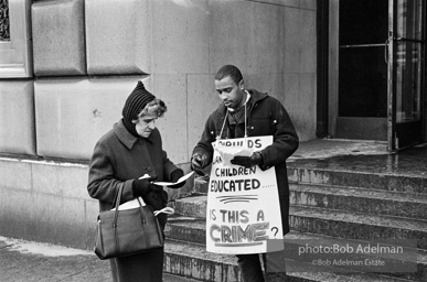 CORE volunteer hands out petition to a passerby.- Brooklyn chapter of the Congress of Racial Equality sit-in at P.S. 200. November, 1962.BE_05-00 001