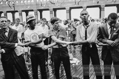 Singing in the rain,  Atlantic City, New Jersey. 1964

“Just back from the horrific and heroic Freedom Summer campaign of 1964, where they were attempting to register black voters in the Deep South, students sang and protested outside the Democratic Party National Convention in Atlantic City. They were asking for color-blind voting laws for delegates and voters alike.”