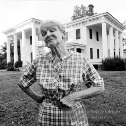 Mrs. Lois Starr stands in front of her mansion, 
