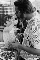 Betsy feeds Silky spareribs at Nathan's. - New York City, 1970. photo:©Bob Adelman. From the book Gentleman of Leisure by Susan Hall and Bob Adelman.