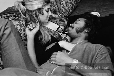 Silky in the living room of his apartment lounging with Toni. She is a transient who has been with Silky on ans off for three years and works as a call girl in Washington, D.C. New York City, 1970. photo:©Bob Adelman. From the book Gentleman of Leisure by Susan Hall and Bob Adelman.