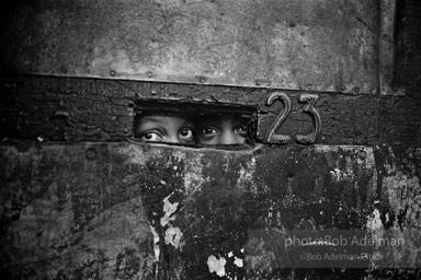 Peering through a mail slot,  Brooklyn,  New York City  1963