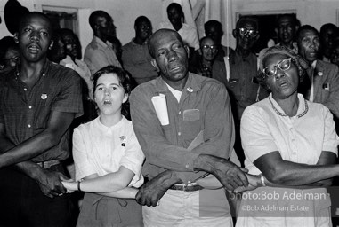 Joining the flock, West Feliciana Parish, Louisiana. 1963

“In West Feliciana, an overwhelmingly black parish where no person of color had voted in the twentieth century, volunteer Mimi Feingold urged members of a church congregation to try to vote. She then joined hands with them to sing, ‘This Little Light of Mine.