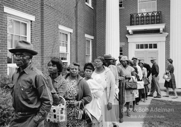 A new day dawns: Voters, most of them about to fill out their first-ever ballots, line up at the courthouse,  Camden, Alabama. 1966-

“The Voting Rights Act of 1965 changed everything, outlawing literacy tests and other barriers. It made it possible for thousands of black officials to eventually be elected in the South, and it certainly helped in
the election of two white southerners to the presidency. It was a large
factor in the gradual decrease of racial tension throughout the South. In a rare show of unity, more than forty years after the Voting Rights Act was passed, Congress renewed the measure unanimously.”