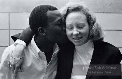 Kime playfully snuggles with an old school chum at a basketball game,  New York City.  1981