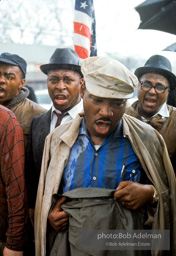 Braving the rain and singing, Martin Luther King leads the Selma to Montgomery march as it approaches it's finale in Montgomery, Alabama. 1965