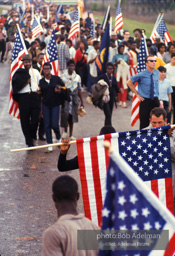 Victorious marchers enter Montgomery displaying American flags at the finale of the Selma to Montgomery march. Alabama. 1965.