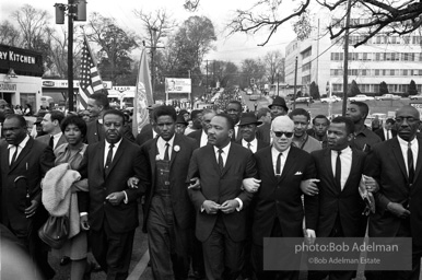 Dr. King leads a protest march around the state capital in Montgomery Alabama protesting the treatment of black demonstrators and voter applicants in Selma, Alabama prior to the Selma to Montgomery march. Montgomery, Alabama. 1965.