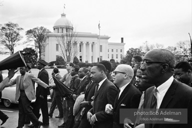 Dr. King leads a protest march around the state capital in Montgomery Alabama protesting the treatment of black demonstrators and voter applicants in Selma, Alabama prior to the Selma to Montgomery march. Montgomery, Alabama. 1965.