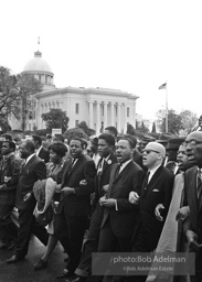 Dr. King leads a protest march around the state capital in Montgomery Alabama protesting the treatment of black demonstrators and voter applicants in Selma, Alabama prior to the Selma to Montgomery march. Montgomery, Alabama. 1965.