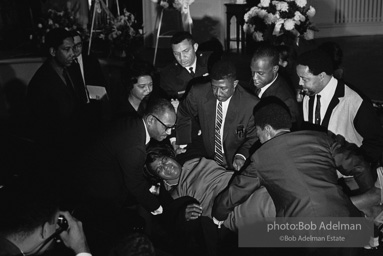 Grief stricken woman collapses after viewing King's open coffin. Atlanta,GA.1968