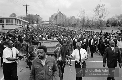 Free at last: King goes to his rest,  Atlanta, Georgia.   1968-


“With more than 50,000 mourners from all over the world following, King’s earthly remains were borne on a simple country wagon pulled by two mules. It was fitting: A wooden wagon was basic transport for the disadvantaged and disinherited, the people he served in his very public ministry. King’s life was dedicated to service. He studied, strategized, exhorted, prayed, marched, pleaded, protested, negotiated and spoke, all to remedy long-standing injustices. “In his Gehenna he suffered vilification, numerous jailings, ’round-the-clock telephone threats, stonings, several bombings, a stabbing, repeated beatings, cross burnings, nervous exhaustion and, finally, an assassin’s bullet. King died serving the dispossessed, and they understood this and adored him for it. Country people would and did drop to their knees as he passed, bawling out,     ‘de Lawd!’”