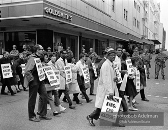 At the memorial just after Martin Luther King's asassination, mourners gather downtown , Some display picket signs 