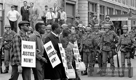 At the memorial just after Martin Luther King's asassination, mourners gather downtown , Some display picket signs 