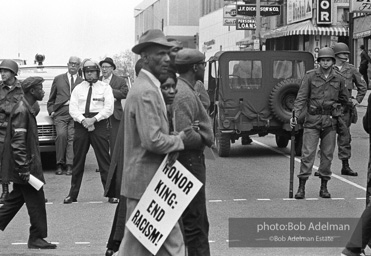 At the memorial just after Martin Luther King's asassination, mourners gather downtown , Some display picket signs 