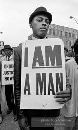 At the memorial just after Martin Luther King's asassination, mourners gather downtown , Some display picket signs 