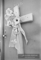 A marker, a cross with flowers, memorialises  room 306 of the Lorraine hotel in front of whic Dr. King was slain. Memphis, TN 1968.