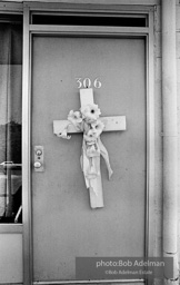 A marker, a cross with flowers, memorialises  room 306 of the Lorraine hotel in front of whic Dr. King was slain. Memphis, TN 1968.