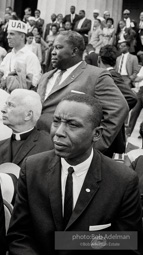 Seated on the podium Core chairman Floyd McKissick listens to speaches by his fellow civil rights leaders.