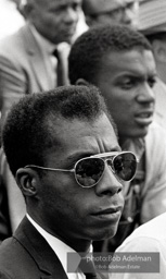 James Baldwin, sitting next to heroic Freedom Rider Jerome Smith, listens attentively to speakers at the ceremony in front of the Lincoln Memorial.  March on Washington. 1963.