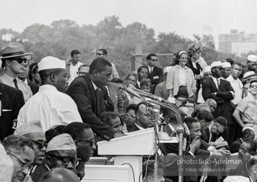 In national director James Farmer's absence Floyd McKissick, chairman of Core, addresses the March. Mrs. King and Dr. King are visible on the podium. Washington D.C. August 28, 1963.