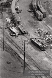1968. Queens, New YorkPassenger cars are demolished in a train yard near a new housing development. East Jamaica between Hollis and St. Albans. Jamaica, Queens, N.Y. 1968