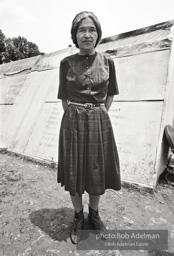 Rosa Parks stands in front of a shanty at 