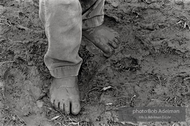 Child walks in mud in the streets of 