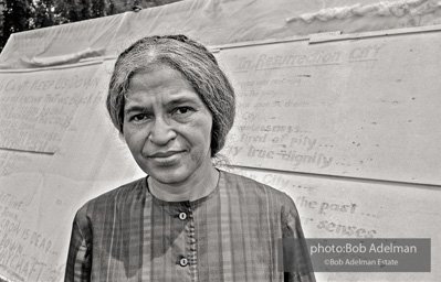 Rosa Parks stands in front of a shanty at 