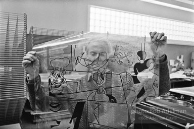 Roy Lichtenstein inspects a litho film for the Tel Aviv mural. Tyler Graphics Studio, Mt. Kisco, NY. 1989. photo:©Bob Adelman Estate, Artwork©Estate of Roy Lichtenstein