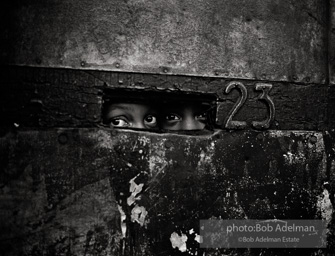 Peering through a mail slot,  Brooklyn,  New York City  1963