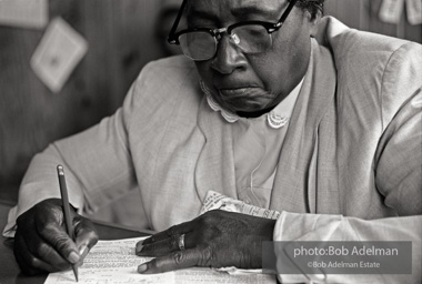 Woman filling out a sample registration form in Frank Robinson’s office, Sumter, SC 1962