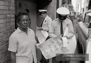 Woman being arrested for picketing at Loveman’s department store, Birmingham 1963
This protestor was picketing the lunch counter at Loveman’s department store. Her sign is a powerful
indictment of the denial of basic rights to blacks.
