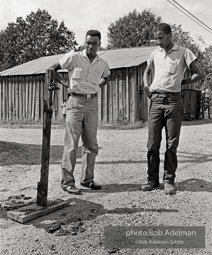 Two men looking at burnt cross West Feliciana Parish, LA 1963. The night after Rev. Joseph Carter became the first black person to register in West Feliciana Parish since the 1920s, crosses were burned across East and West Feliciana parishes by the KKK and its sympathizers. Two men looking at burnt cross West Feliciana Parish, LA 1963. The night after Rev. Joseph Carter became the first black person to register in West Feliciana Parish since the 1920s, crosses were burned across East and West Feliciana parishes by the KKK and its sympathizers.