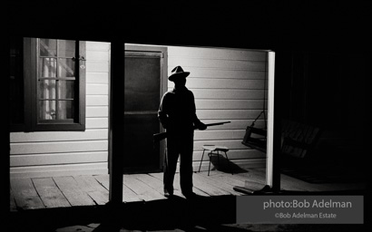 Reverend Carter, expecting a visit from the Klan after he has dared to register to vote, stands guard on his front porch,  West Feliciana Parish, Louisiana. 1964-


“After Reverend Carter had registered to vote, that night vigilant neighbors scattered in the woods near his farmhouse, which was at the end of a long dirt road, to help him if trouble arrived. ‘If they want a fight, we’ll fight,’ Joe Carter told me. ‘If I have to die, I’d rather die for right.’ “He told me, ‘I value my life more since I became a registered voter. A man is not a first-class citizen, a number one citizen, unless he is a voter.’ After Election Day came and went, Reverend Carter added, ‘I thanked the Lord that he let me live long enough to vote.’”