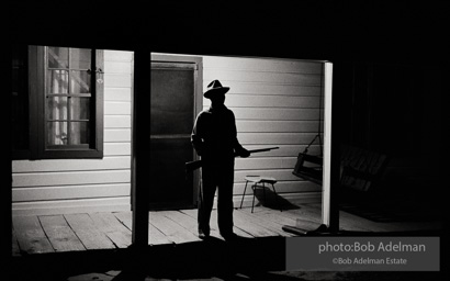 Reverend Carter, expecting a visit from the Klan after he has dared to register to vote, stands guard on his front porch, West Feliciana Parish, Louisiana. 1964-
“After Reverend Carter had registered to vote, that night vigilant neighbors scattered in the woods near his farmhouse, which was at the end of a long dirt road, to help him if trouble arrived. ‘If they want a fight, we’ll fight,’ Joe Carter told me. ‘If I have to die, I’d rather die for right.’ “He told me, ‘I value my life more since I became a registered voter. A man is not a first-class citizen, a number one citizen, unless he is a voter.’ After Election Day came and went, Reverend Carter added, ‘I thanked the Lord that he let me live long enough to vote.’” Reverend Carter, expecting a visit from the Klan after he has dared to register to vote, stands guard on his front porch, West Feliciana Parish, Louisiana. 1964-
“After Reverend Carter had registered to vote, that night vigilant neighbors scattered in the woods near his farmhouse, which was at the end of a long dirt road, to help him if trouble arrived. ‘If they want a fight, we’ll fight,’ Joe Carter told me. ‘If I have to die, I’d rather die for right.’ “He told me, ‘I value my life more since I became a registered voter. A man is not a first-class citizen, a number one citizen, unless he is a voter.’ After Election Day came and went, Reverend Carter added, ‘I thanked the Lord that he let me live long enough to vote.’”