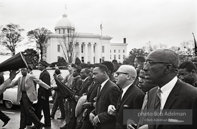 Dr. King leads a protest march around the state capital in Montgomery Alabama protesting the treatment of black demonstrators and voter applicants in Selma, Alabama prior to the Selma to Montgomery march. Montgomery, Alabama. 1965.